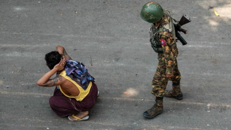 Dieser Soldat bewacht einen verhafteten Demonstranten in der Stadt Mandalay. (Bild: APA/AFP/STR)