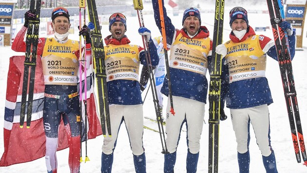 Norwegens Johannes Hoesflot Kläbo, Hans Christer Holund, Emil Iversen und Paal Golberg feiern die Goldmedaille. (Bild: AFP/Christof Stache)