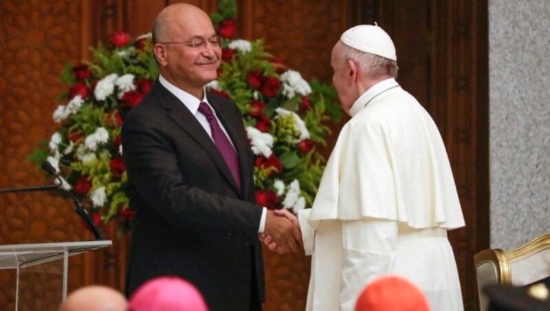 Trotz Corona-Risiko schütteln einander der irakische Präsident Barham Salih und Papst Franziskus die Hände. (Bild: AP)