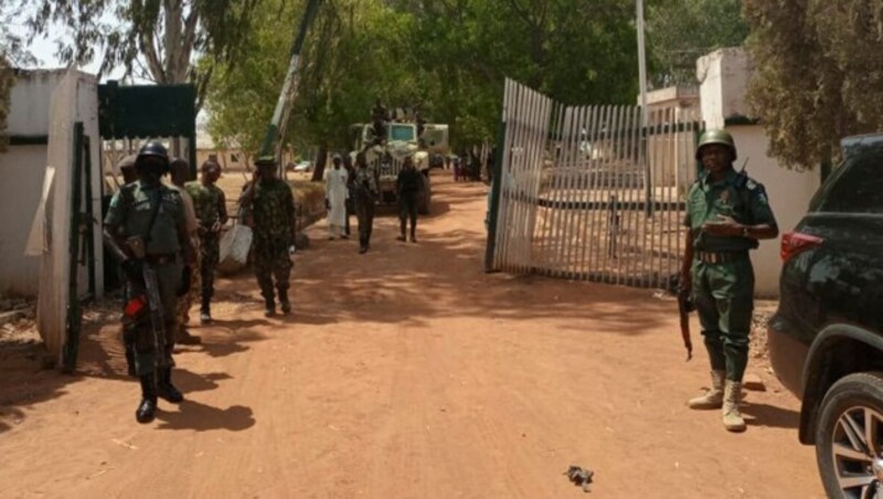 Nigerianische Sicherheitskräfte stehen am Tor der Schule in Mando. Eine Bande hatte die Einrichtung gestürmt und fast 40 Schüler entführt. (Bild: APA/AFP/Bosan Yakusak)