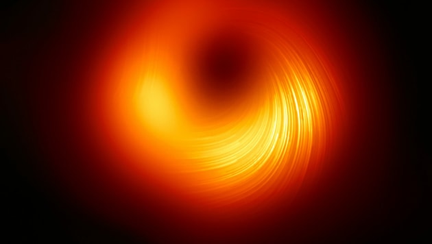 Dieses Bild zeigt die Ansicht der Polarisation des Schwarzen Lochs in M87. Die Linien markieren die Ausrichtung der Polarisation, die mit dem Magnetfeld um den Schatten des Schwarzen Lochs zusammenhängt. (Bild: EHT Collaboration)