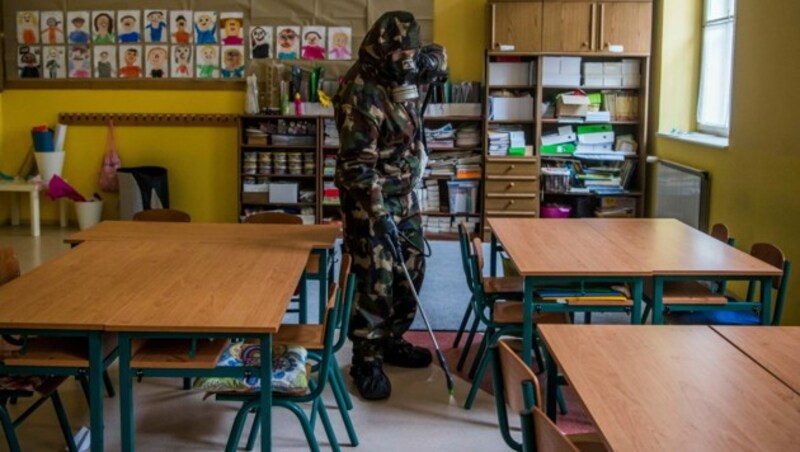 Ein ungarischer Soldat desinfiziert ein Klassenzimmer (Bild: Zoltan Balogh/MTI via AP)