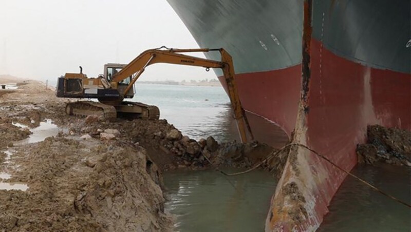 Ein kleiner Bagger für ein riesgies Containerschiff - Bisher scheiterten die Versuche, das Containerschiff zu befreien. (Bild: -)