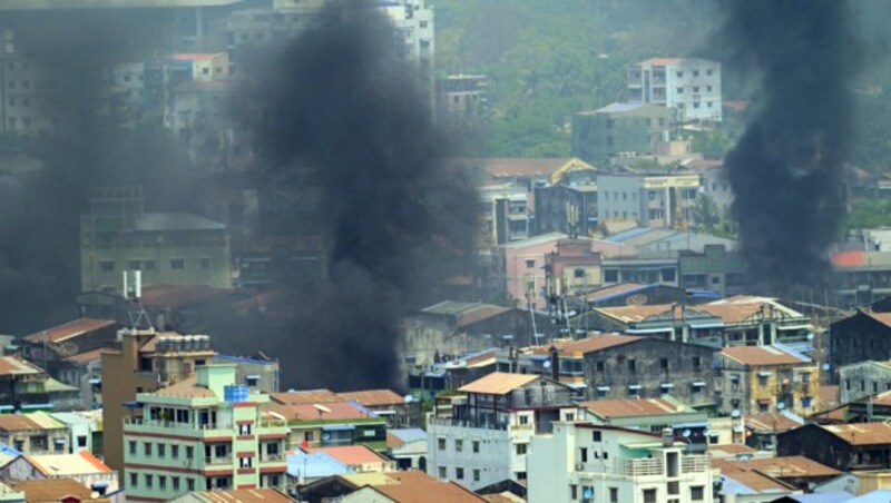 Rauch steigt auf über Yangon, nachdem Sicherheitskräfte gewaltsam gegen Demonstranten vorgegangen sind. (Bild: APA/AFP/STR)