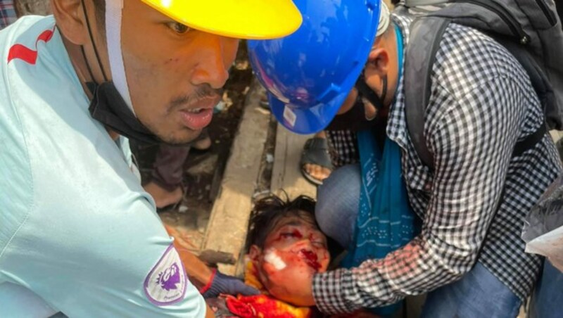 Sanitäter versorgen einen angeschossenen Demonstranten. (Bild: APA/AFP/DAWEI WATCH/Handout)