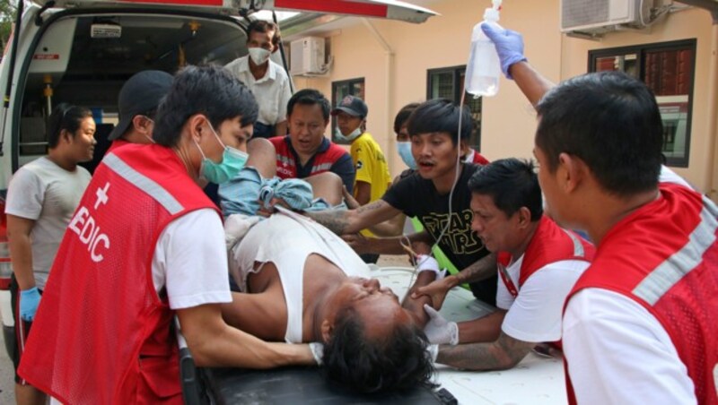 Ein verletzter Demonstrant in Yangon wird von Sanitätern ins Krankenhaus gebracht. (Bild: AP)