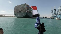Ein Mann schwenkt zum Abschied des Frachters die ägyptische Flagge. (Bild: AP)