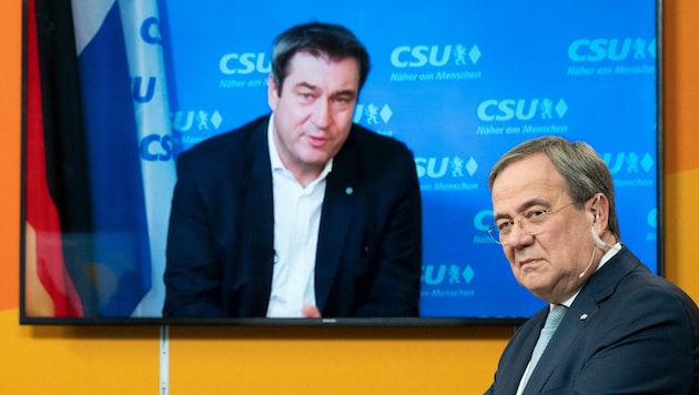 Armin Laschet (re.), und Markus Söder rittern um Merkels Erbe. (Bild: AFP)