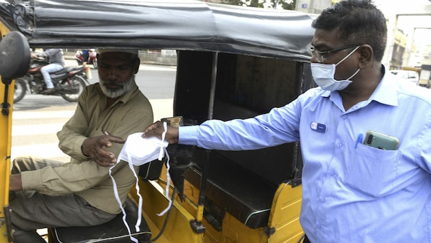Indien: Masken werden ausgegeben, um das Virus an der Verbreitung zu hindern. (Bild: AFP)