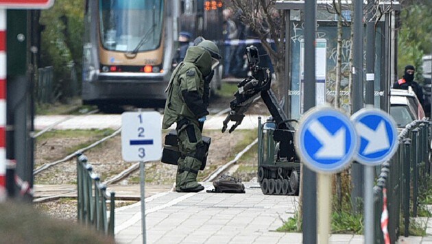 Ein Sprengstoffexperte untersucht mithilfe eines Roboters ein verdächtiges Objekt in einem Vorort von Brüssel. Die Ermittlungen standen in Zusammenhang mit den vereitelten Terrorplänen vor der Fußball-EM 2016 in Frankreich. (Bild: APA/AFP/PATRIK STOLLARZ)