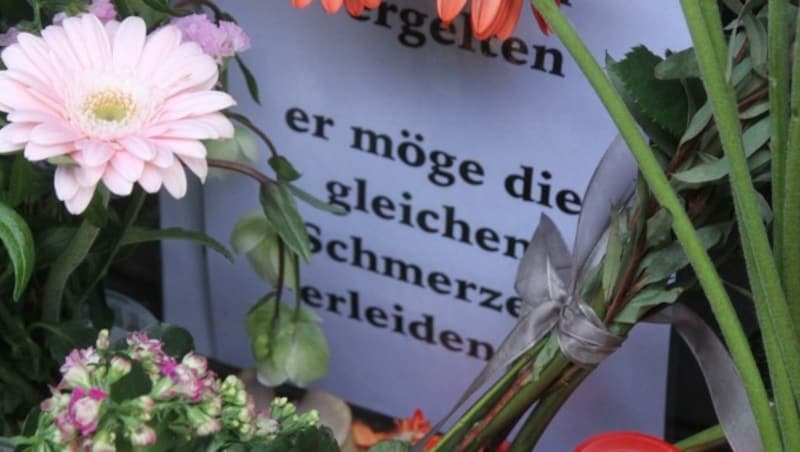 Verwandte, Freunde und Kunden der beliebten Trafikantin zünden jetzt am Tatort Grabkerzen an - und legen dort Blumen und Briefe nieder. (Bild: Schiel Andreas)