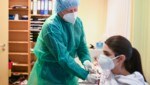 Der deutsche Arzt Klaus Renckhoff impft eine Frau gegen das Coronavirus in seiner Ordination mit dem Biontech-Vakzin. (Bild: AFP)