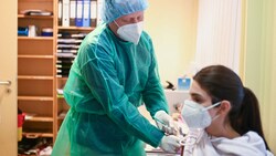 Der deutsche Arzt Klaus Renckhoff impft eine Frau gegen das Coronavirus in seiner Ordination mit dem Biontech-Vakzin. (Bild: AFP)