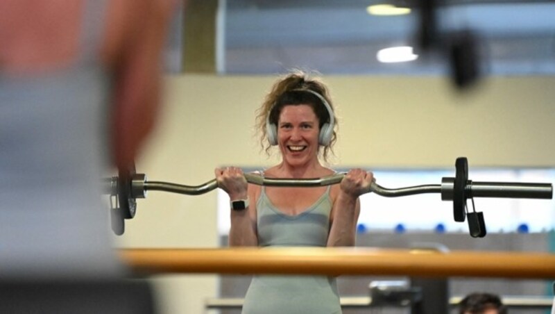 Eine Frau genießt ihre Trainingseinheit in einem Londoner Fitnesscenter sichtlich. (Bild: DANIEL LEAL-OLIVAS / AFP)