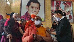 Unter den wachsamen Augen des Königs Jigme Khesar Namgyel (am Bild an der Wand) wurde dieser Mönch in Bhutan geimpft. (Bild: AFP)