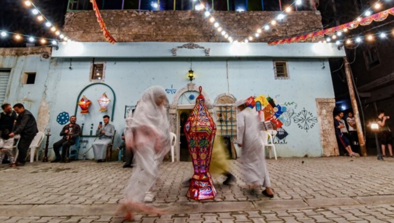 Kinder in Mosul (Irak) tanzen während eines Straßenfests anlässlich des Beginn des Ramadan um eine Laterne. (Bild: Zaid AL-OBEIDI / AFP)