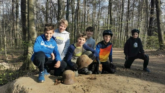 Die Jugendlichen mit den gefundenen Helmen im Leechwald. (Bild: Clemens Wieser)