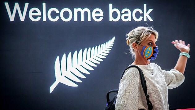 Eine aus Neuseeland zurückgeflogene Passagierin auf dem Flughafen von Sydney (Bild: APA/AFP/David Gray)