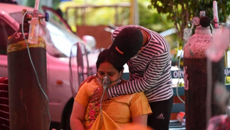 In Ghaziabad wird eine Frau am Straßenrand mit Sauerstoff versorgt. Auch hier sind die Krankenhäuser überfüllt. (Bild: AFP)