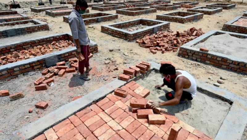 Wegen der rapide steigenden Todeszahlen bauen indische Arbeiter Plattformen zum Kremieren von Covid-19-Toten. (Bild: AFP)