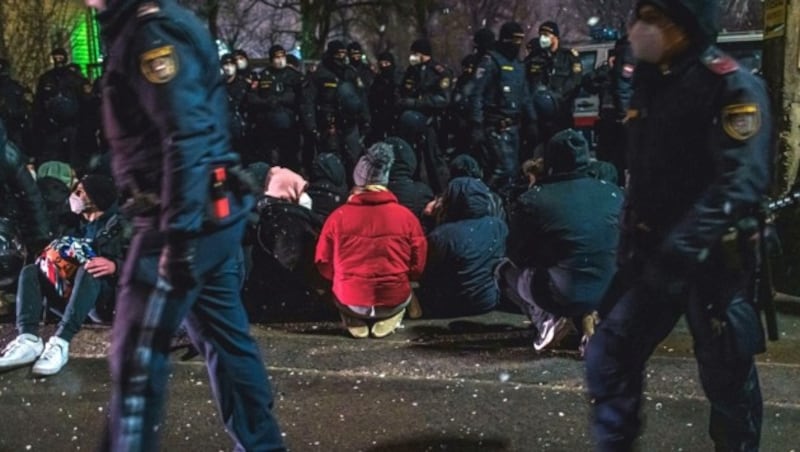 Demonstranten und Polizeikräfte vor der Auflösung der Protestaktion in Wien-Simmering (Bild: APA/CHRISTOPHER GLANZL)