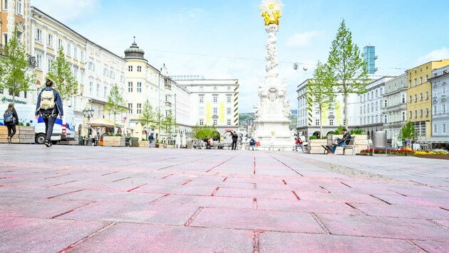 Der „rote Platz“ von Linz - nach einer PR-Aktion der SPÖ am 1. Mai geht die Farbe nicht mehr ab. Die städtischen Hauptplatzreiniger kümmern sich nun darum. (Bild: Alexander Schwarzl)