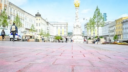 Der „rote Platz“ von Linz - nach einer PR-Aktion der SPÖ am 1. Mai geht die Farbe nicht mehr ab. Die städtischen Hauptplatzreiniger kümmern sich nun darum. (Bild: Alexander Schwarzl)