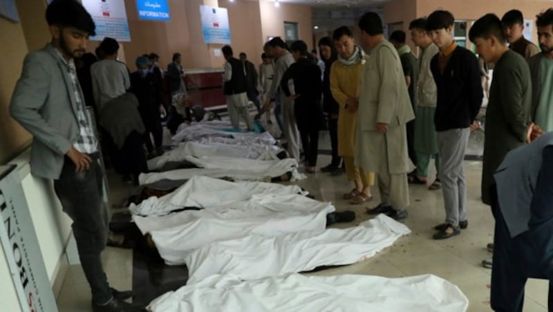 Angehörige versuchen die Opfer der Explosion nahe einer Schule in Kabul zu identifizieren. (Bild: AP)