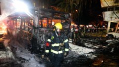 In der Stadt Holon in der Nähe Tel Avivs brannte ein von einem Flugkörper getroffener Bus aus. (Bild: APA/AFP/Ahmad GHARABLI)