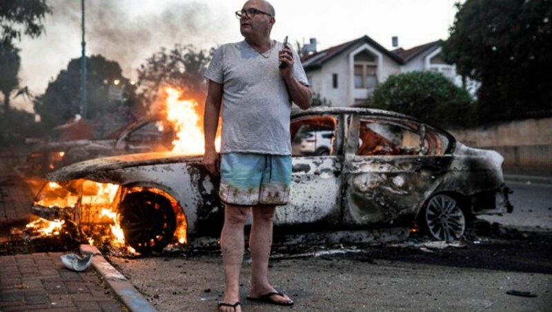 Ein Einwohner von Lod vor seinem brennenden Auto (Bild: ASSOCIATED PRESS)