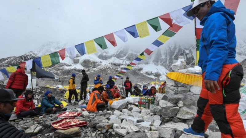 Bergsteiger, Sherpas und Expeditionsführer nehmen vor dem Aufstieg an einem buddhistischen Ritual teil. (Bild: PRAKASH MATHEMA / AFP)