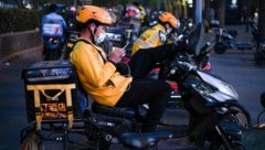 Lieferanten des Online-Zustellers Meituan in China warten auf den nächsten Auftrag.
