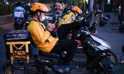 Lieferanten des Online-Zustellers Meituan in China warten auf den nächsten Auftrag.