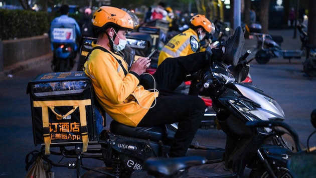 Lieferanten des Online-Zustellers Meituan in China warten auf den nächsten Auftrag.