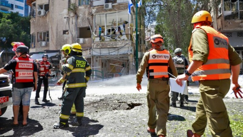 Nach einem Raketeneinschlag in Tel Aviv sind Einsatzkräfte am Samstag mit Aufräumarbeiten beschäftigt. (Bild: AFP )