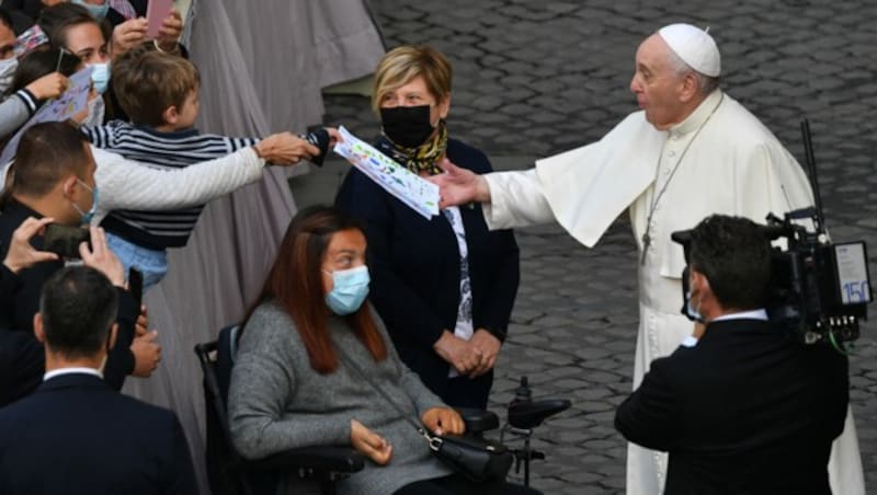 Ein Kind schenkt dem Papst am 12. Mai eine Zeichnung. (Bild: APA/AFP/Tiziana FABI)