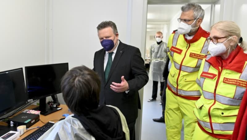 Bürgermeister Michael Ludwig, Samariterbund-Geschäftsführer Oliver Löhlein und die ärztliche Leiterin Susanne Drapalik in einer „Gurgel-Box“ (Bild: APA/HERBERT NEUBAUER)