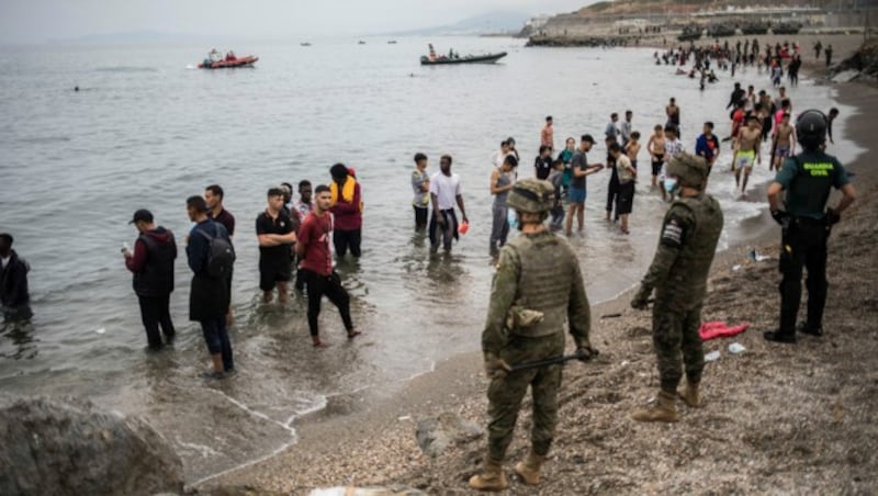 Spanische Soldaten verhindern das Weiterkommen der Migranten aus Marokko. (Bild: AP)