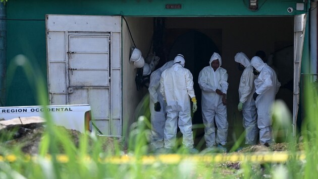 Forensiker untersuchen das Haus des ehemaligen Polizisten Hugo Ernesto Osorio, in dem die Überreste von mindestens 14 Mordopfern gefunden wurden. (Bild: AFP)