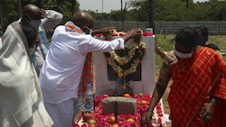 In der Nähe der indischen Stadt Hyderabad legen Menschen Blumen am Grab eines an Covid-19 verstorbenen Verwandten nieder. (Bild: AP)