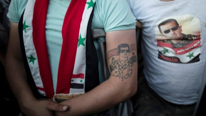 Die Loyalität dieses syrischen Soldaten zu Assad geht sogar unter die Haut. (Bild: Associated Press)