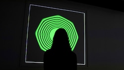 Eine Frau beim Betrachten von Kevin McCoys digitalem Kunstwerk „Quantum“ (Bild: AFP)