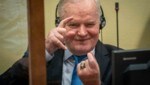 Ratko Mladic ohne Reue - beim Prozess imitierte er die Fotografen, die Bilder von ihm schossen. (Bild: AP)