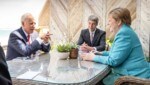 US-Präsident Joe Biden im Gespräch mit der deutschen Bundeskanzlerin Angela Merkel, flankiert von ihrem außenpolitischen Berater Jan Hecker (Bild: APA/AFP/Bundesregierung/Guido Bergmann)