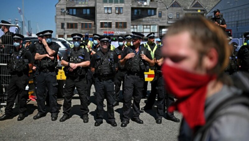 Demonstranten sorgten für zum Teil originelle Choreografien, die Polizei für Ordnung und Sicherheit in Cornwall. (Bild: APA/AFP/Oli SCARFF)