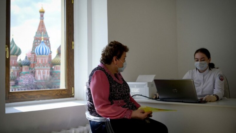 Eine Frau bei ihrem Beratungsgespräch vor der Corona-Impfung hat einen sagenhaften Ausblick auf den Kreml. (Bild: AFP)