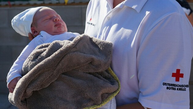 Rettungssanitäter Raphael Leeb hält Baby Lukas Conrad im Arm (Bild: RK Eferding)