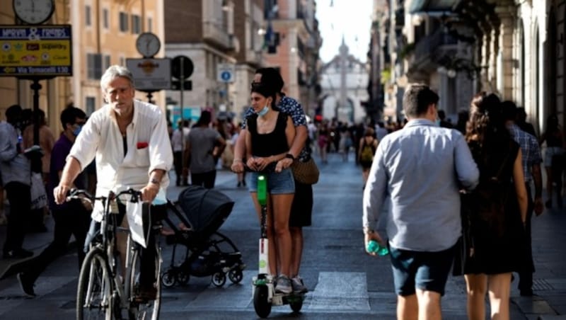 Bei den hohen Temperaturen werden die Italiener die Maske im Freien wohl nicht vermissen. (Bild: AFP )