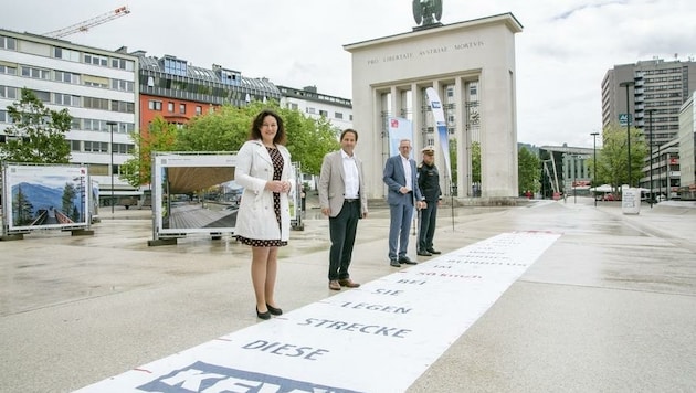 Anhand eines 14 Meter langen Blindflugteppichs zeigten LHStv. Ingrid Felipe, KFV-Vertreter Martin Pfanner, Bernhard Knapp (Abteilung Verkehrsrecht) und Polizist Günther Salzmann (von links) beim Auftakt der Bezirkstour in Innsbruck die Auswirkungen von Ablenkung auf. (Bild: APA)