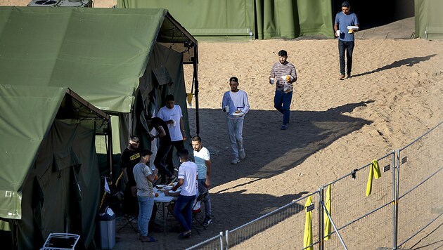 Migranten in einem neu errichteten Auffanglager in der Stadt Pabrade (Bild: AP)